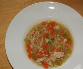 Chicken and barley soup in a white bowl