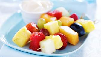 Skewers of fruit on a blue plate